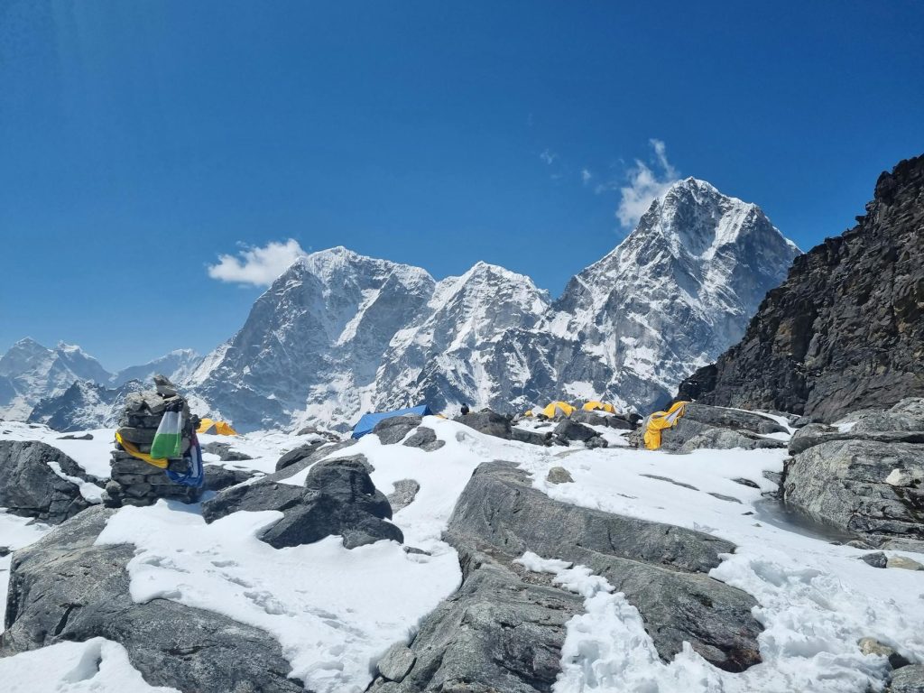 flags on rocks near mount everest